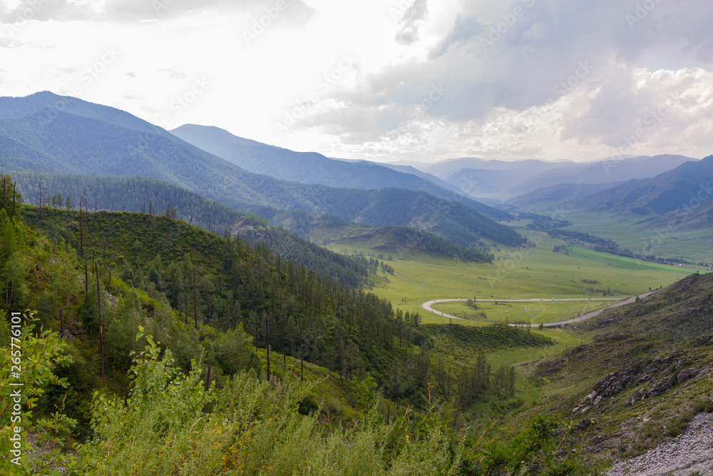 Altai Mountain valley with white clouds. Summer time. Mountain car pass.