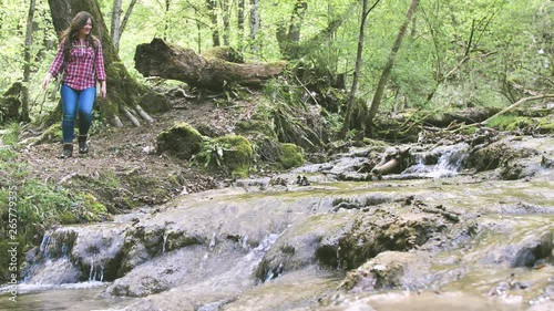 junge Frau mit dem Rucksack, wandert im wald in der nehe vom wasserfall photo