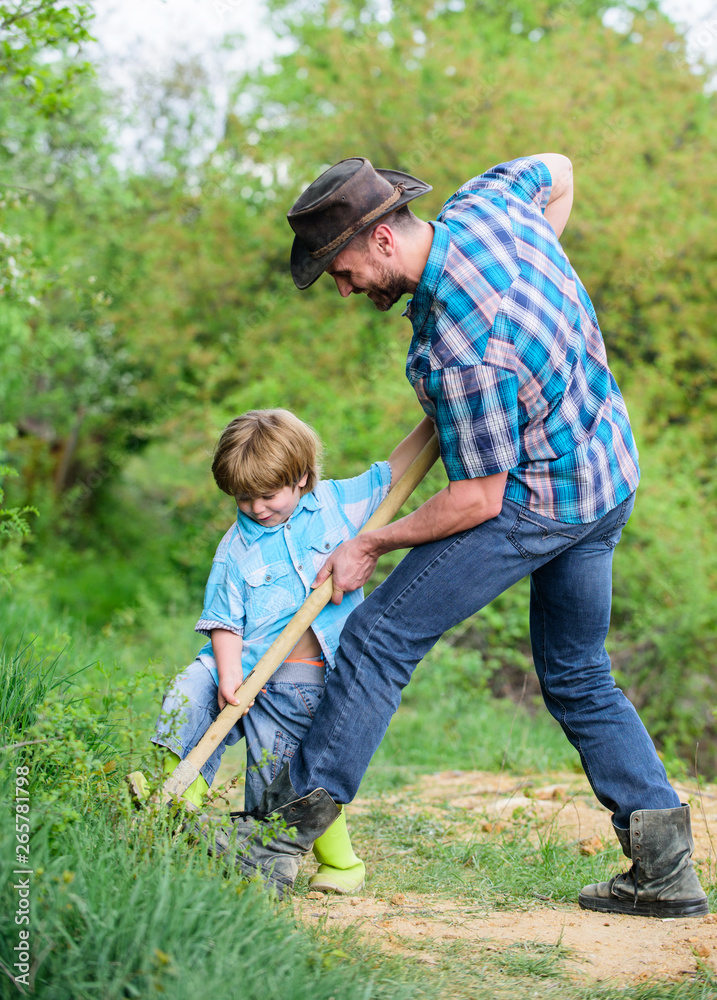 Little helper in garden. Cute child in nature having fun with cowboy dad. Find treasures. Little boy and father with shovel looking for treasures. Happy childhood. Adventure hunting for treasures Little helper in garden. Cute child in nature having fun with cowboy dad. Find treasures. Little boy and father with shovel looking for treasures. Happy childhood. Adventure hunting for treasures