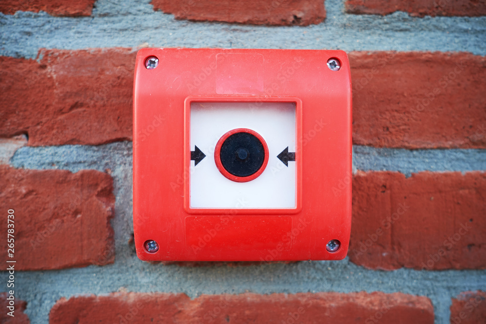 fire alarm red button on a brick wall