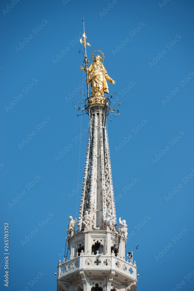 Golden Virgin Mary statue on top roof of Duomo Golden Virgin Mary statue on top roof of Duomo