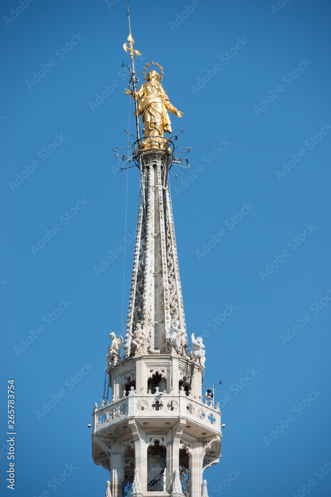 Golden Virgin Mary statue on top roof of Duomo Golden Virgin Mary statue on top roof of Duomo