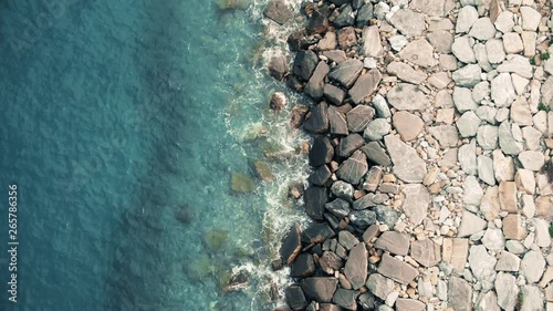 Aerial view waves break on the rocks