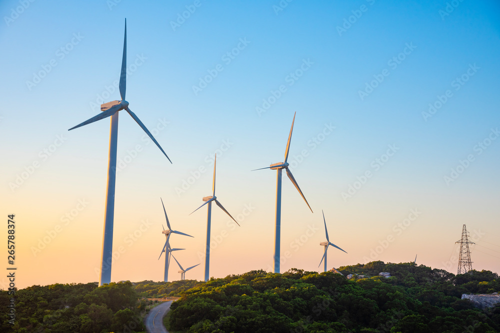 Wind turbines on the mountains are on the beach at sunrise and sunset. Wind turbines on the mountains are on the beach at sunrise and sunset.