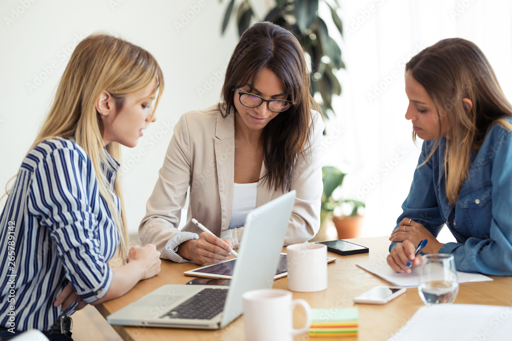Shot of pretty young businesswoman showing progress of work in digital tablet to co-workers in the office. Shot of pretty young businesswoman showing progress of work in digital tablet to co-workers in the office.