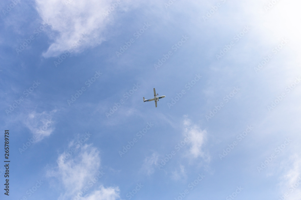 Airplane flying in the blue sky among clouds and sunlight Airplane flying in the blue sky among clouds and sunlight
