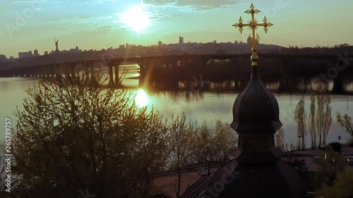 Aerial view of a wooden church with a large golden cross near the wide river Dnieper in Kiev photo