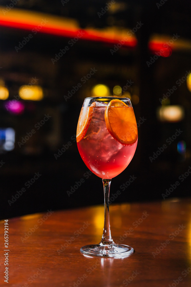 A refreshing cold cocktail with ice and orange slices in a wine glass