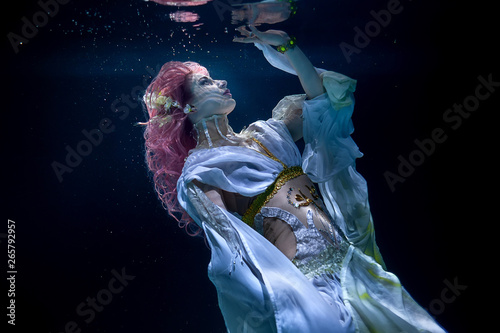 Fotografie woman with pink hair in white dress underwater