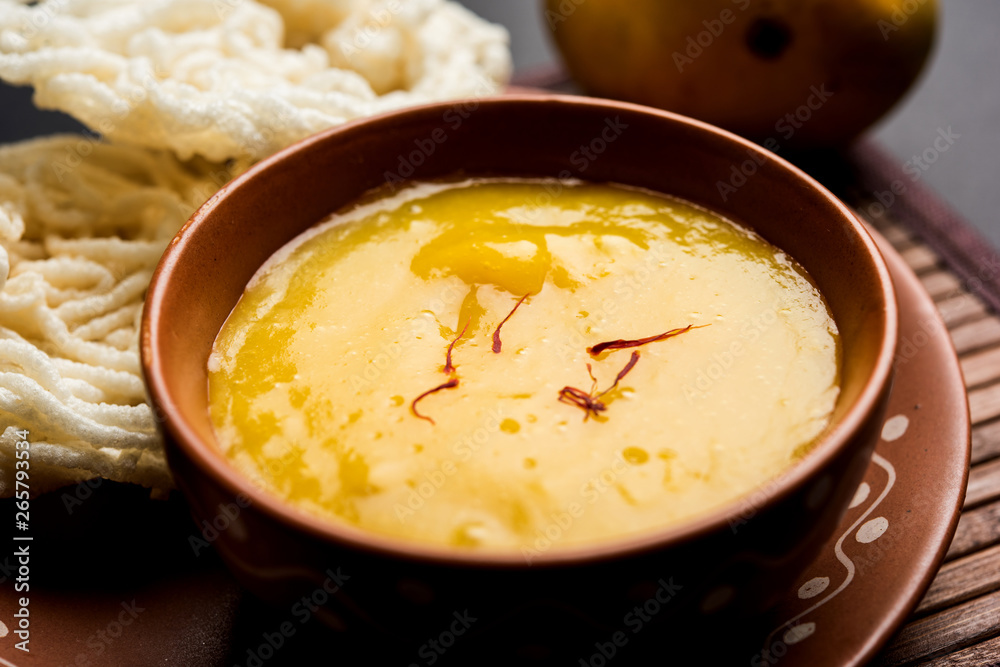 Aam Ras or Alphonso mango pulp with kurdai which is a fried dish made using wheat/gehu. selective focus Aam Ras or Alphonso mango pulp with kurdai which is a fried dish made using wheat/gehu. selective focus