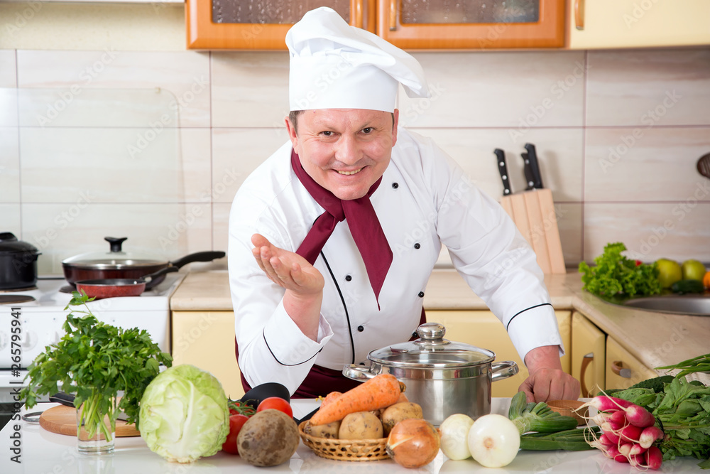 Portrait of a male cook in the kitchen. Male chef cooks food. Portrait of a male cook in the kitchen. Male chef cooks food.