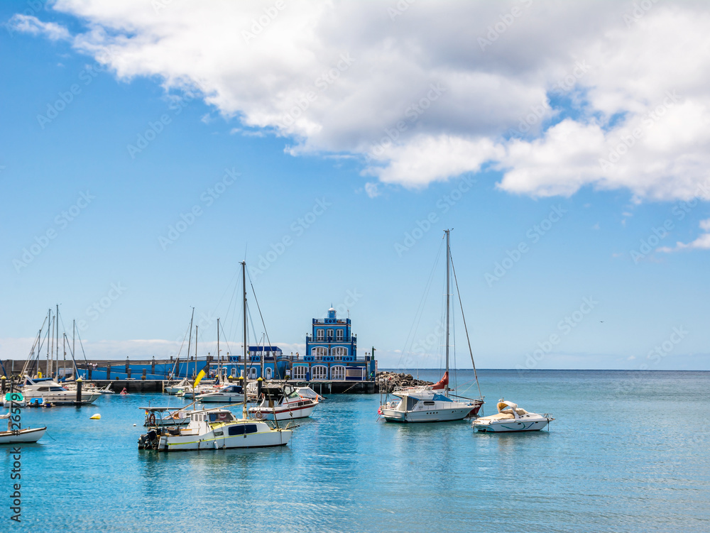 Blue harbormaster house and view over the beautiful sunny harbour of Marina del Sur in Las Galletas. Tenerife, Canary Islands, Spain. Artistic picture. Beauty world.