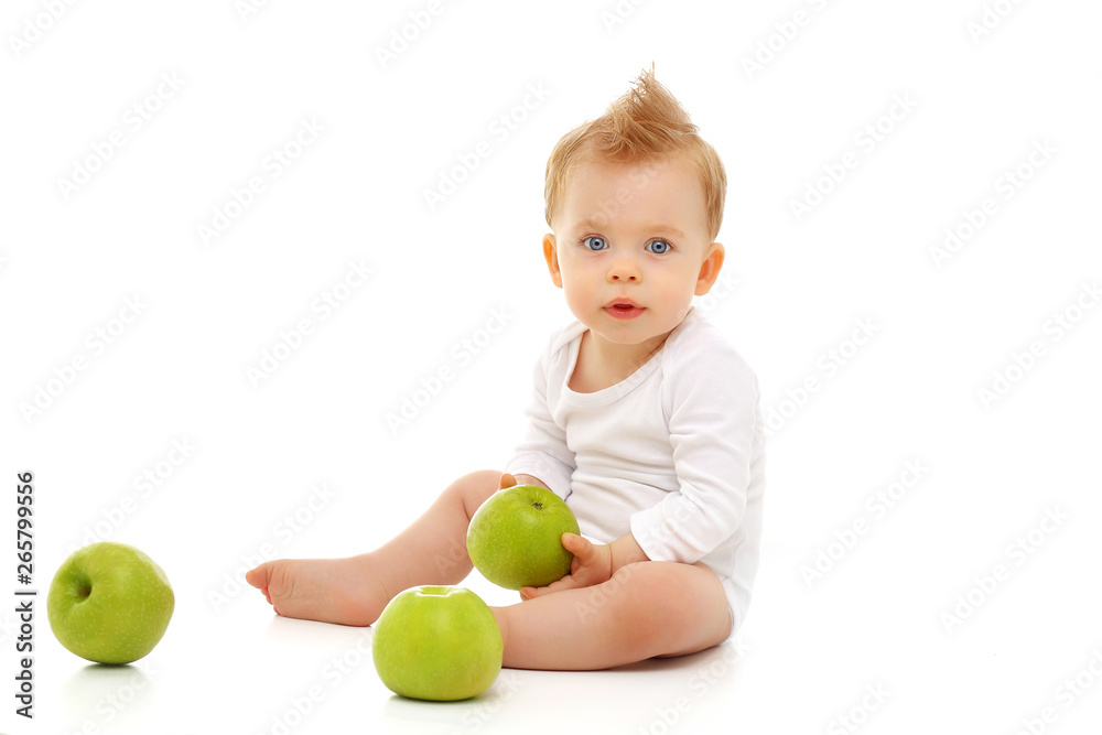 Baby 11 months old in white bodysuit sitting on white background with green apples Baby 11 months old in white bodysuit sitting on white background with green apples
