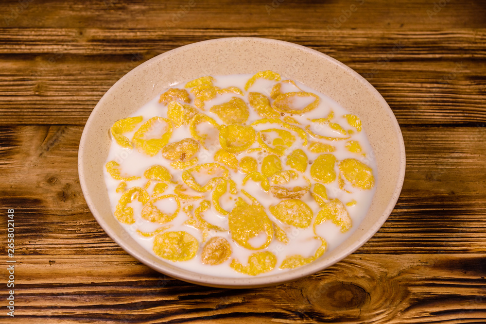 Ceramic plate with cornflakes and milk on a wooden table. Healthy eating Ceramic plate with cornflakes and milk on a wooden table. Healthy eating