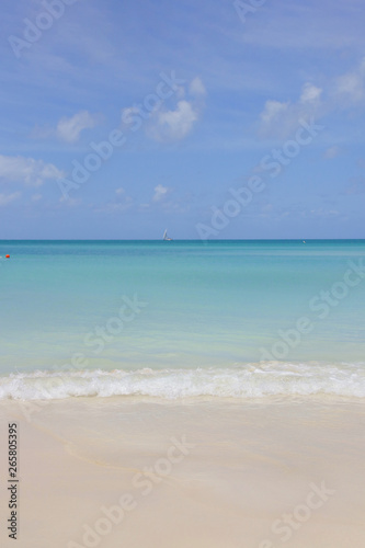 Sand Beach of Antigua  dream beach with a little sailboat on the horizon  Caribbean Sea