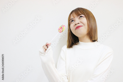 easterner girl eating colourful lollipop. photo
