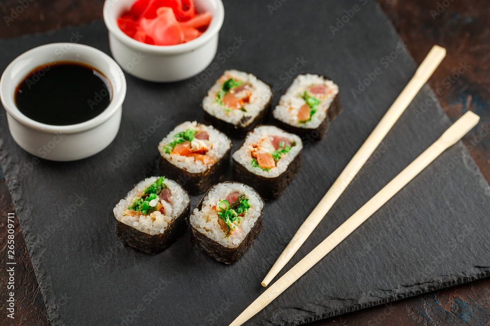Japanese sushi on a rustic dark background. Japanese sushi on a rustic dark background.