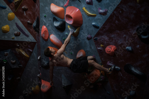 Athletic man practicing in a bouldering gym