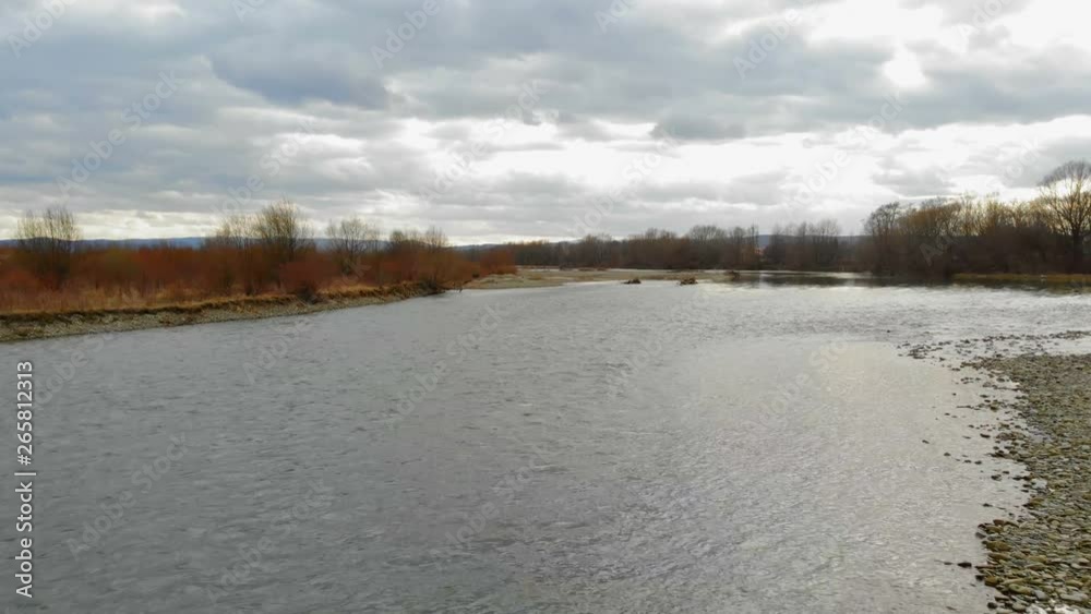 Low flying drone over the river with rocks.