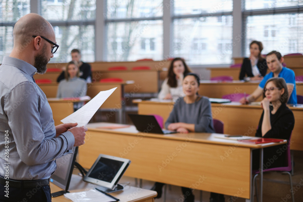 Lecturer and multinational group of students in an auditorium Lecturer and multinational group of students in an auditorium