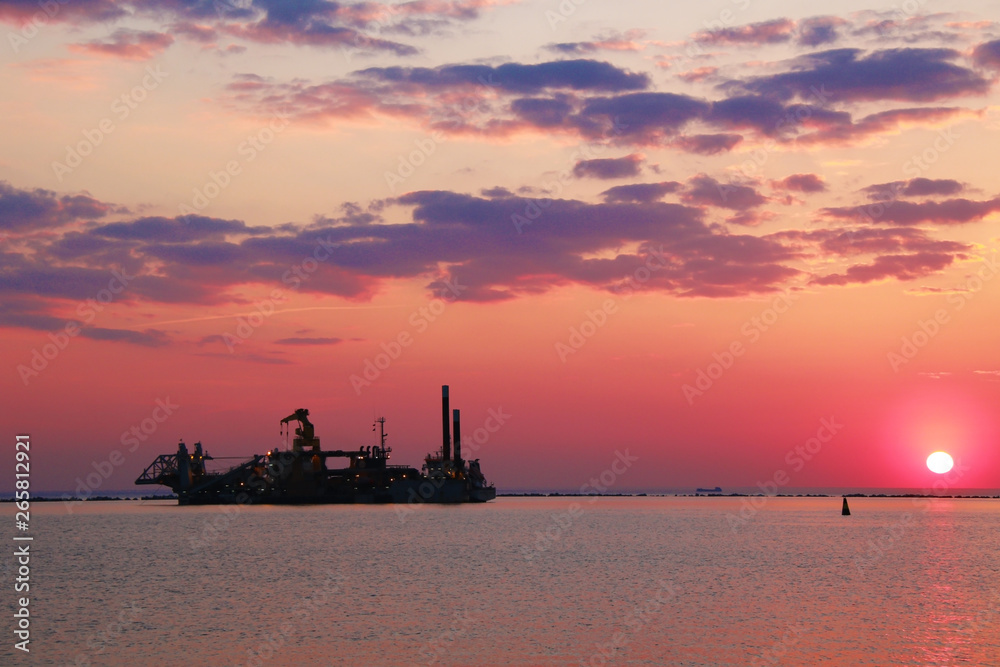 Ship silhouette and sunset over the sea