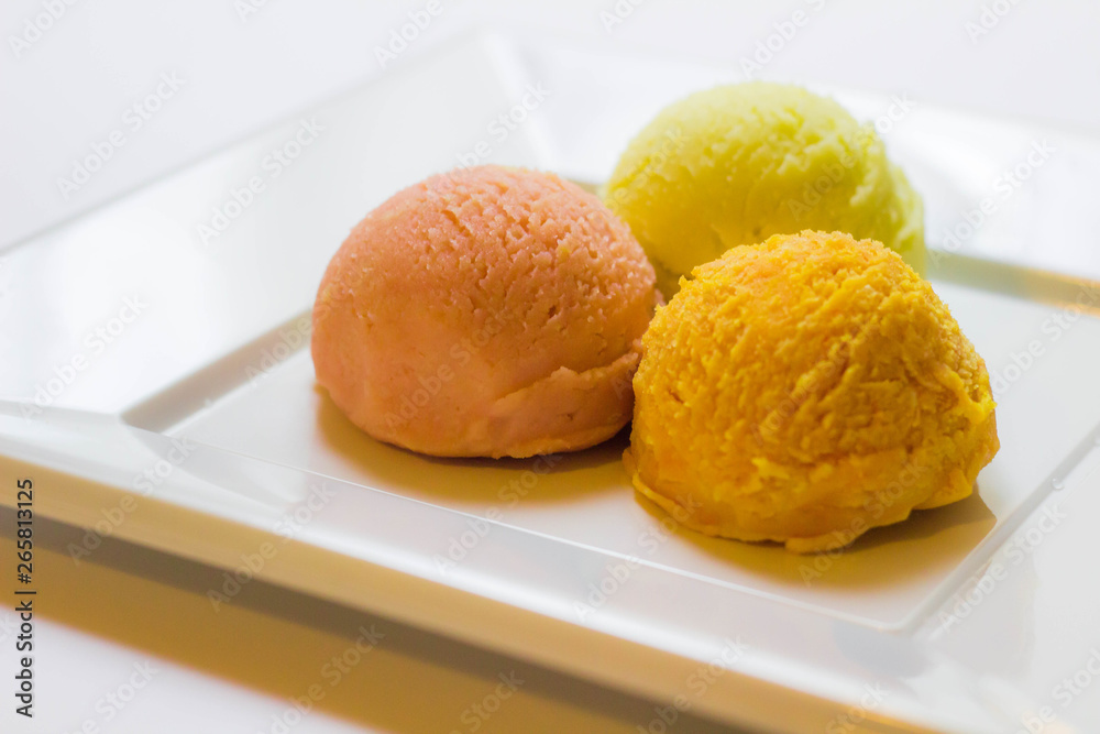 Set of ice cream scoops of different colors and flavours with fruits decoration isolated on white background Set of ice cream scoops of different colors and flavours with fruits decoration isolated on white background