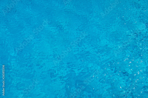 Blue ripped water in swimming pool. Surface of blue swimming pool, background of water in swimming pool. Water swimming pool texture and surface water on pool. Blue ripped water in swimming pool.