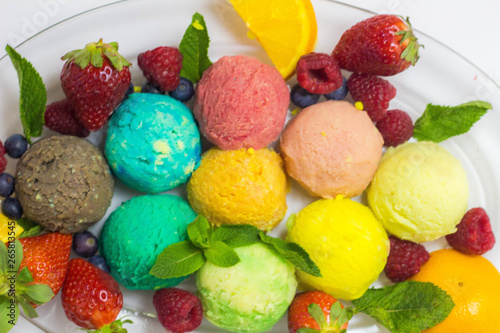 Set of ice cream scoops of different colors and flavours with fruits decoration isolated on white background 