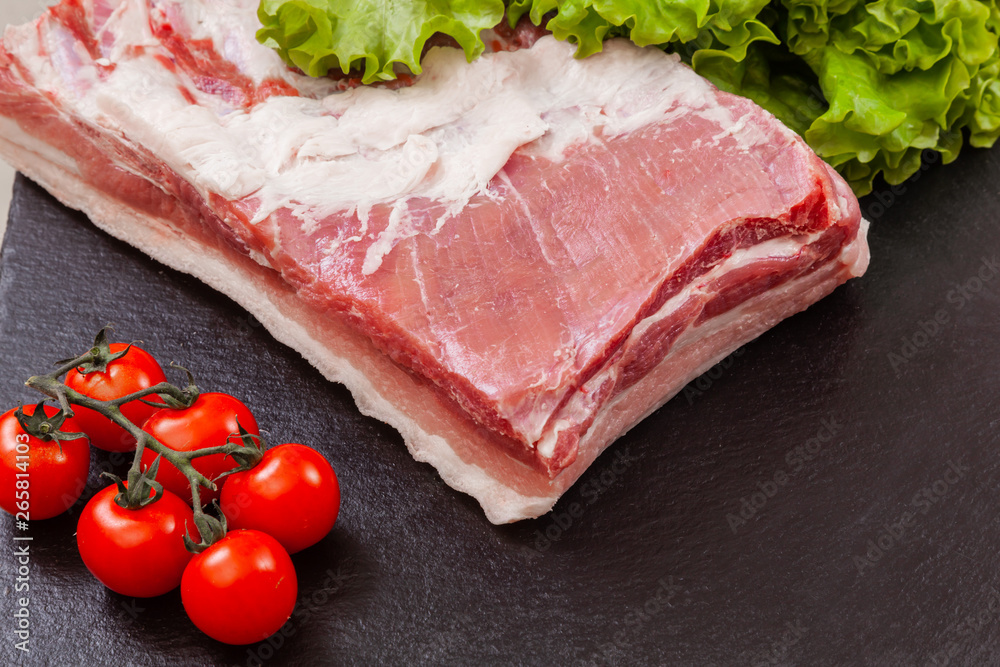 a piece of pork meat on the black plate a piece of pork meat on the black plate