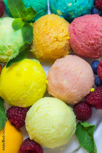 Set of ice cream scoops of different colors and flavours with fruits decoration isolated on white background 