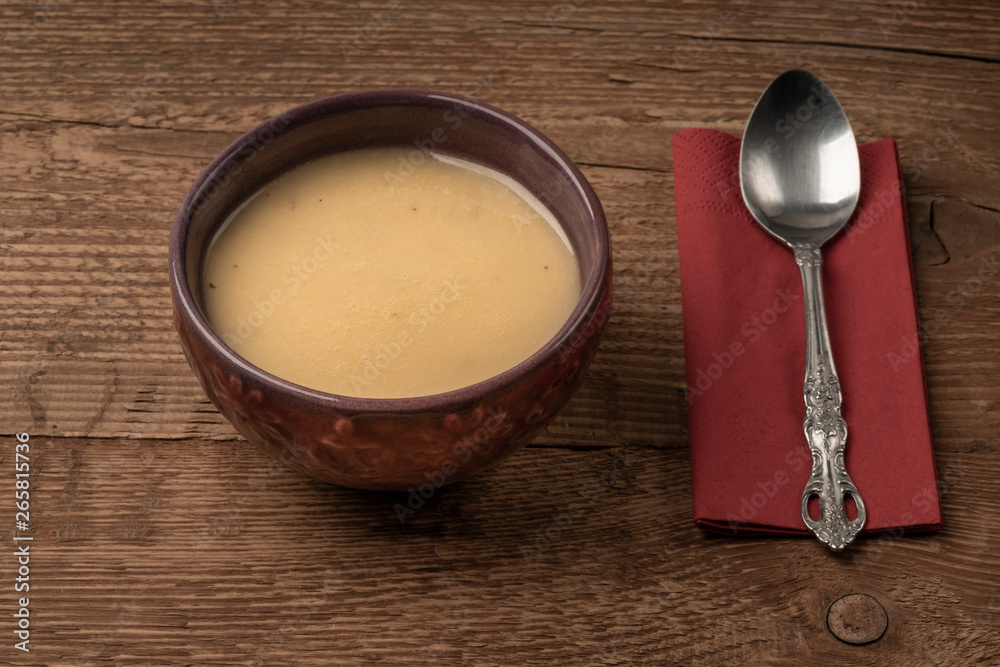 a bowl of soup on wooden table a bowl of soup on wooden table