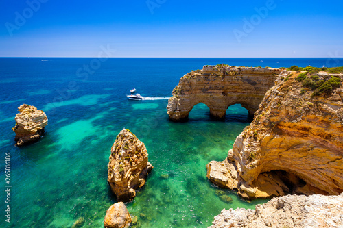 Natural caves at Marinha beach, Algarve Portugal. Rock cliff arches on Marinha beach and turquoise sea water on coast of Portugal in Algarve region. photo