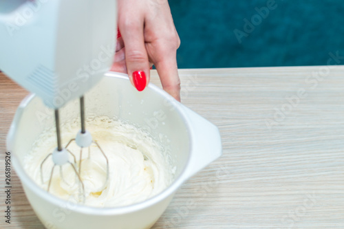 Mixer whips cream cake. Close-up. Close up. Woman hands.