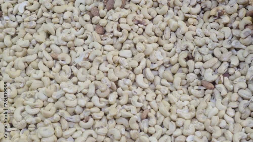 Rotating, panning shot across lots of fresh peeled, natural cashew nuts laid out on flat surface. Rotating, panning shot across lots of fresh peeled, natural cashew nuts laid out on flat surface.