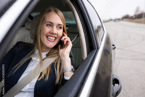 Beautiful businesswoman is talking on her phone while driving the car © Milana