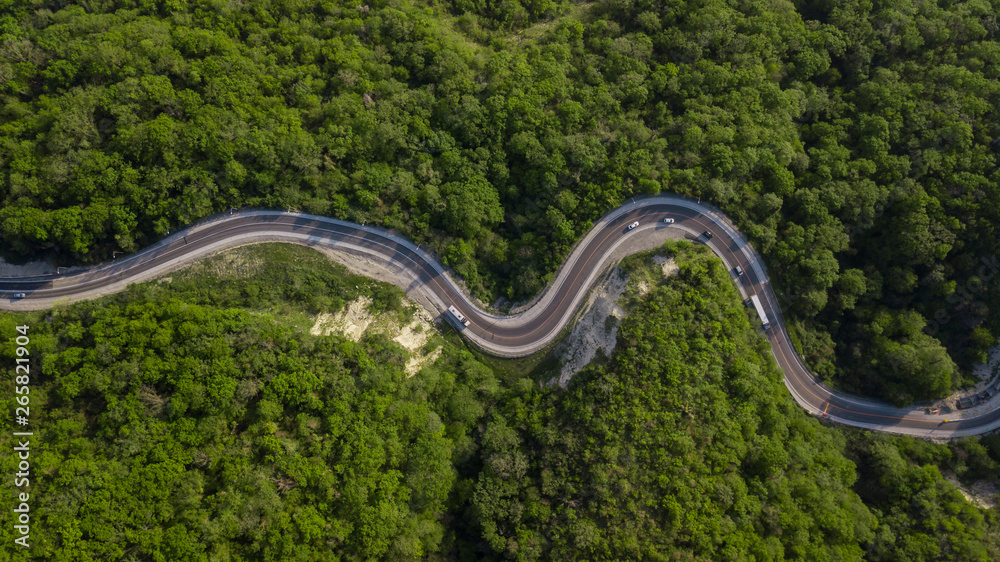 Aerial top down view: of cars driving on zig zag winding mountain road Aerial top down view: of cars driving on zig zag winding mountain road
