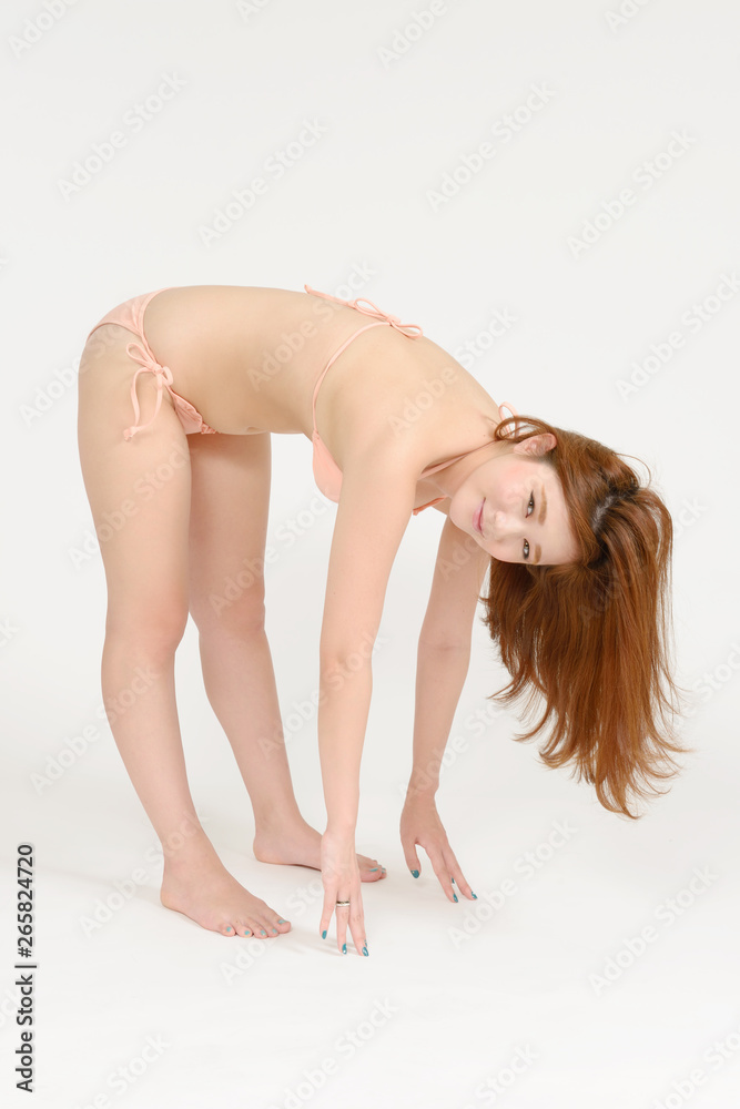 Obraz premium ストレッチする水着の若い女性