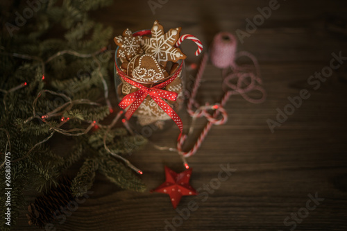 Homemade gingerbread in the glass jar with fir branches on the background, spices and decor. Holidays, winter, Christmas presents concept. Merry Christmas and Happy Holidays. Toned image. Soft focus.