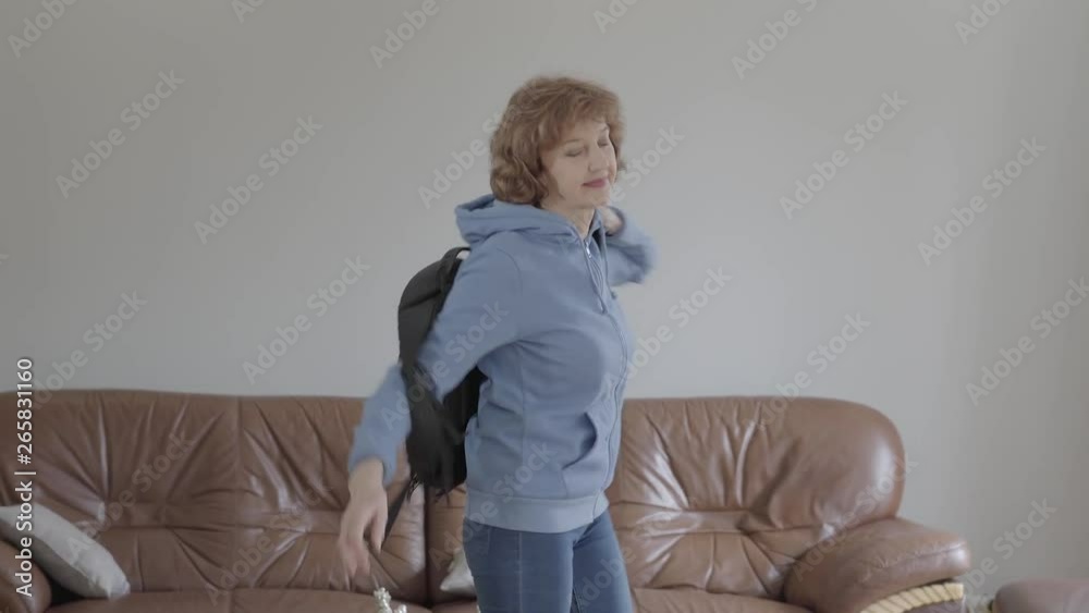 Beautiful adult smiling woman taking a backpack from the couch going on a trip. Beautiful adult smiling woman taking a backpack from the couch going on a trip.