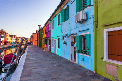 Street with colorful buildings in Burano island, Venice, Italy. Architecture and landmarks of Burano, Venice postcard. Scenic canal and colorful architecture in Burano island near Venice, Italy © daliu