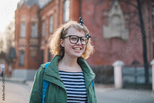 Portrait of a young woman on the background of a European sunny street.