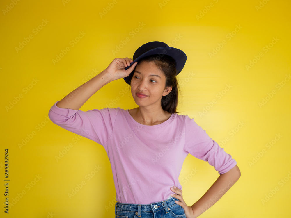 beautiful young asia woman against yellow wall.
