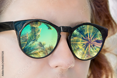 Girl sunglasses, palm trees reflection, tropical summer concept