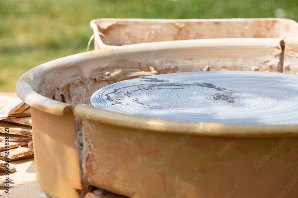 Summer outdoor closeup potter's wheel with bokeh effect. Pottery workspace with depth of field effect Summer outdoor closeup potter's wheel with bokeh effect. Pottery workspace with depth of field effect