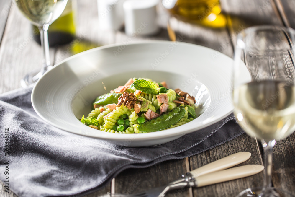 Fusilli pasta with green peas ham walnuts with white wine. italian or mediterranean cuisine Fusilli pasta with green peas ham walnuts with white wine. italian or mediterranean cuisine