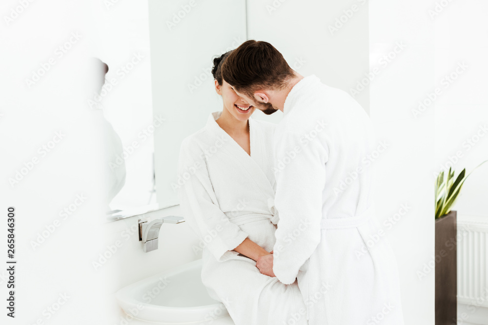 selective focus of man holding hands with cheerful brunette woman in bathroom selective focus of man holding hands with cheerful brunette woman in bathroom