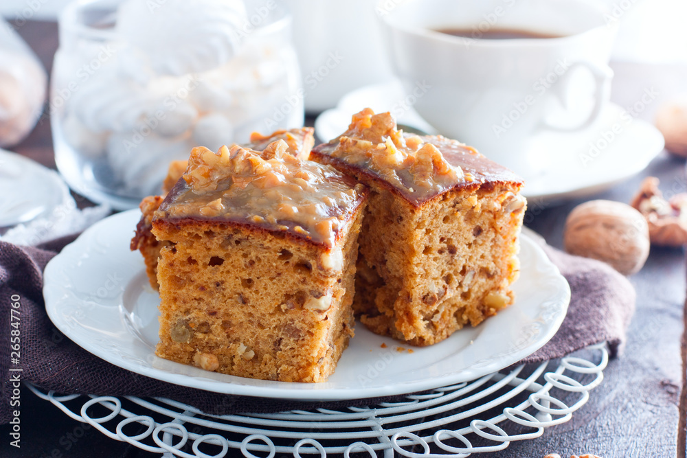 Homemade pie with nuts and raisins boiled condensed milk on a white plate, cut into squares, horizontal Homemade pie with nuts and raisins boiled condensed milk on a white plate, cut into squares, horizontal