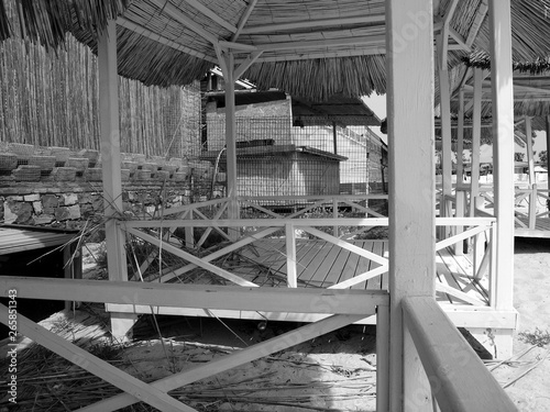 Überdachte Pavillons und Hütten aus Holz im Sommer bei Sonnenschein am Strand in der Bucht von Alacati bei Cesme am Ägäischen Meer in der Provinz Izmir in der Türkei in klassischem Schwarzweiß photo