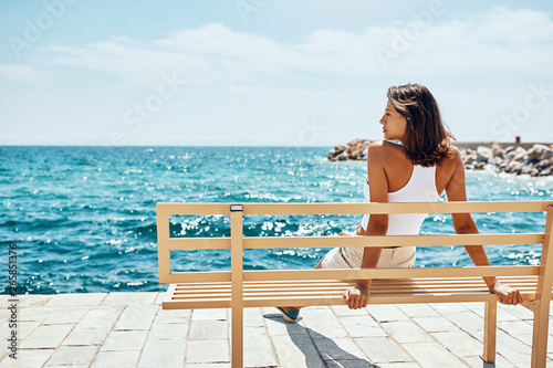 woman taking a break in front of the sea during summer vacation. photo