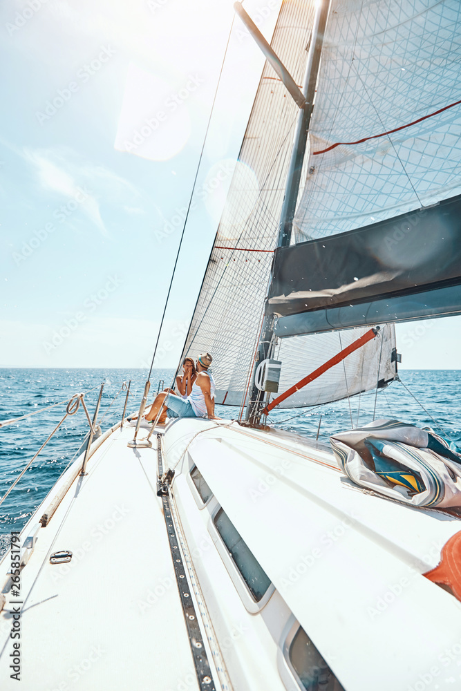 Obraz premium Young couple spending happy time on a yacht at sea.